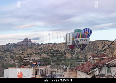 Une photo de ballons d'air chaud volant au-dessus de la ville de Göreme au lever du soleil. Banque D'Images