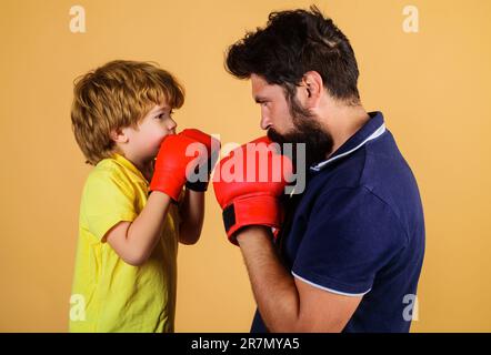 Petit garçon avec entraîneur de boxe. Boxeur pour garçons pratiquant des coups de poing avec un coach. Père et fils pendant l'entraînement de boxe. Enfant dans la boxe gants de formation avec Banque D'Images