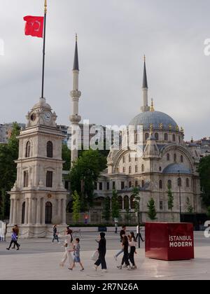 Mosquée de Tophana alias Mosquée Nusretiye, avec clocher, Istanbul, Turquie. Les gens passent devant profiter de la chaude soirée. Banque D'Images
