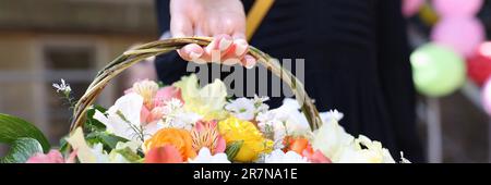 Panier avec bouquet de fleurs brillantes dans les mains Banque D'Images