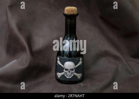 petite bouteille de poison, étiquette avec crâne blanc sur fond noir Banque D'Images petite bouteille de poison, étiquette avec crâne blanc sur fond noir Banque D'Images