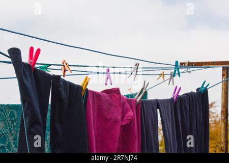 Une épingle à linge est suspendue sur la ligne de lavage. Une corde avec du linge propre et des vêtements à l'extérieur le jour de la lessive. Sur fond de nature verte Banque D'Images