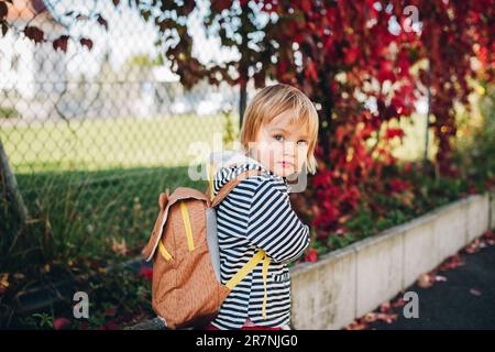 Portrait extérieur d'une petite fille adorable, à vélo, portant un sac à dos Banque D'Images