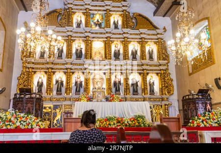 Cebu, Cebu, Philippines-17 janvier 2023: Beaucoup de catholiques philippins dévorés, viennent à genoux, prient et rendent grâce à l'autel, avec ses saints, ses anges, et Banque D'Images