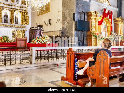 Cebu, Cebu, Philippines-17 janvier 2023: Beaucoup de catholiques philippins dévorés, viennent à genoux, prient et rendent grâce à l'autel, avec ses saints, ses anges, et Banque D'Images