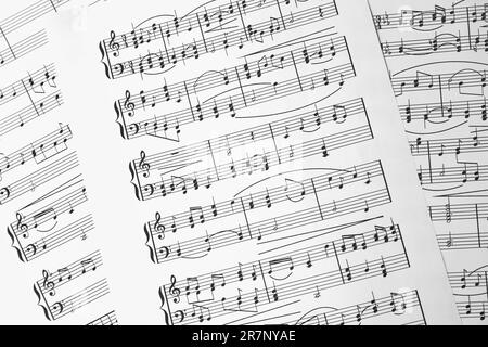 Feuilles de musique. Mélodies écrites avec différents symboles musicaux comme fond, gros plan Banque D'Images