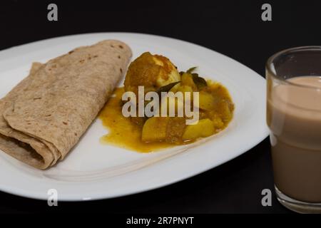 Petit déjeuner de style indien du Nord. Chappathi et Curry d'œufs sur fond noir isolé Banque D'Images