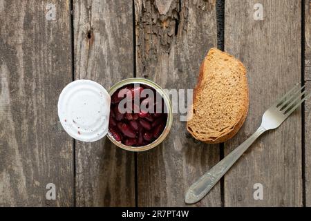 haricots rouges dans un pot en fer sur la table de la cuisine pour le déjeuner à côté d'une fourchette et d'une tranche de pain Banque D'Images