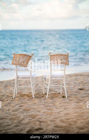 Deux chaises de mariage en bois dans un cadre en bord de plage surplombant l'océan, avec des écrits de M. Mrs Banque D'Images