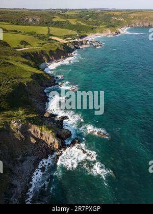 Vue aérienne de la côte sud accidentée des Cornouailles près du village de Kuggar avec l'océan clair se brisant sur les rochers. Banque D'Images