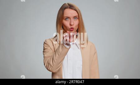 Je vous regarde. Portrait d'une jeune femme d'affaires pointant vers ses yeux et son appareil photo, montrez que je vous regarde le geste, espionnant quelqu'un. Fille en costume. Femme isolée sur fond gris studio Banque D'Images