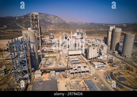 Énorme usine de production de ciment. Vue aérienne des silos tours, tuyaux et autres structures de la zone industrielle Banque D'Images