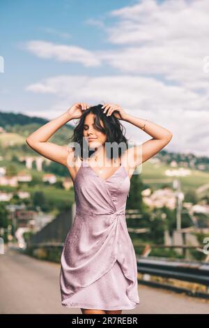 Bonne jeune femme dansant dans la rue, portant une robe pourpre, le bonheur et la liberté Banque D'Images