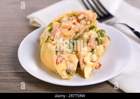 Pâtes conchiglie farcies de morceaux de poulet tendres, de champignons et de légumes dans une riche sauce crémeuse. Banque D'Images