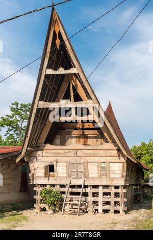 La maison traditionnelle de Batak, en indonésien, appelée Rumah Bolon ou Jabu, sont notées pour leurs toits distinctifs qui courbe vers le haut à chaque extrémité, comme un bateau Banque D'Images