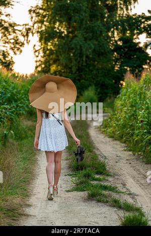 Jeune belle femme avec chapeau d'été dans le champ de maïs Banque D'Images