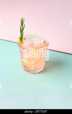 Cocktail Pink Gin avec romarin sur fond pastel Banque D'Images