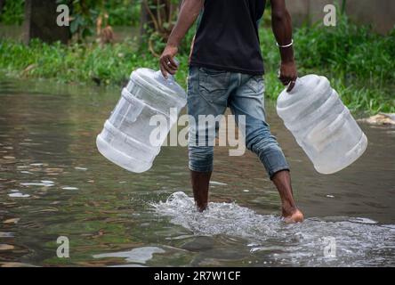 Les navetteurs traversent une rue inondée après de fortes pluies, à Guwahati, Assam, Inde, le 14 juin 2023. L'engorgement est une scène courante dans la ville de Guwahati en raison d'un système de drainage médiocre. Crédit : David Talukdar/Alay Live News Banque D'Images