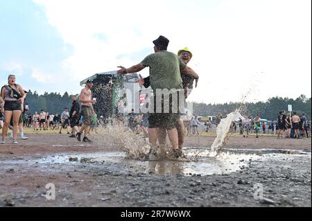 17 juin 2023, Basse-Saxe, Scheeßel: Les festivaliers se tiennent dans une flaque au Festival Hurricane 2023. Un total de 80 concerts sur quatre niveaux sont prévus jusqu'en 18.06.2023. Le festival de musique rock « Hurricane » est l'un des plus grands festivals allemands en plein air. Photo: Lars Penning/dpa Banque D'Images