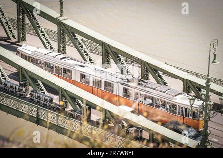 L'ancien tramway jaune traversant le pont vert sur le Danube à Budapest Banque D'Images