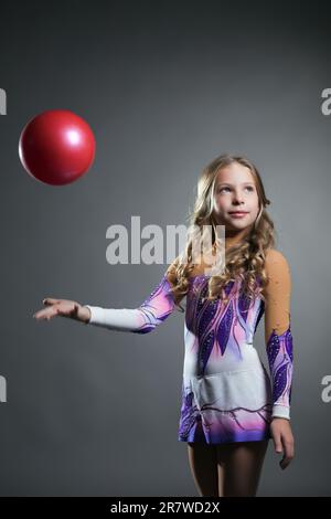 Belle gymnaste artistique lance balle en studio Banque D'Images