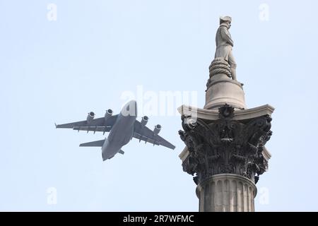 Un avion de transport lourd Globemaster C-17 survole la colonne de Nelsons sur la place Trafalgar, la mouche officielle passé pour marquer le Trooping la couleur ( couleur ) anniversaire officiel du roi Charles le troisième en 2023. Banque D'Images