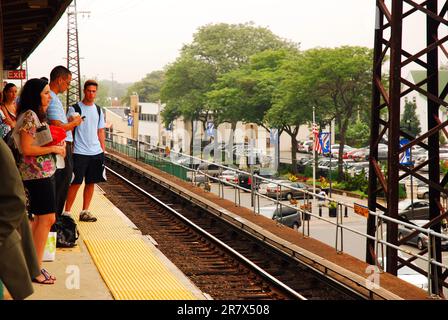 Les navetteurs qui se dirigent vers leur emploi à Manhattan attendent leur train sur une plate-forme de chemin de fer de long Island Banque D'Images