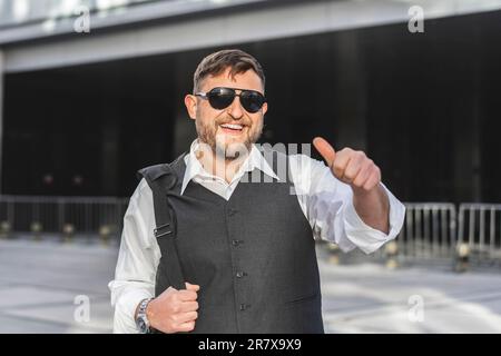 Portrait d'un homme d'affaires souriant regardant l'appareil photo avec son pouce devant son bureau Banque D'Images