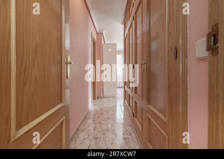 Vestibule d'une chambre avec placards en chêne, sols en grès et murs peints en rose Banque D'Images