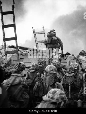 Le premier lieutenant Baldomero Lopez, USMC, dirige le peloton de 3rd, Compagnie A, 1st Bataillon, 5th Marines au-dessus de la digue sur le côté nord de Red Beach, comme la deuxième vague d'assaut atterrit, le 15 septembre 1950, pendant l'invasion d'Inchon. Des échelles à échelle en bois sont utilisées pour faciliter le débarquement du LCVP qui a amené ces hommes à la rive. Le lieutenant Lopez a été tué en action en quelques minutes Banque D'Images