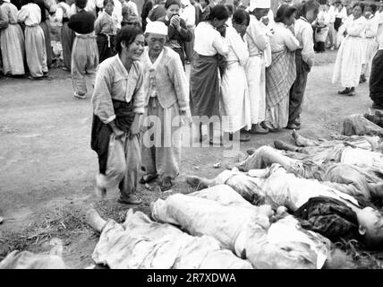 Les Coréens de Hamhung identifient les corps de quelque 300 prisonniers politiques qui ont été tués par l'armée nord-coréenne en étant forcés dans des grottes qui ont ensuite été fermées pour qu'ils soient morts par asphyxie. 19 octobre 1950. Banque D'Images