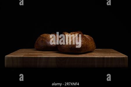 Pains croustillants faits maison au levain sur fond de bois. Concept STILL Life. Sombre moody. Banque D'Images