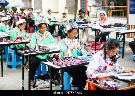 Les brodeurs travaillent dans un atelier à Qianxinan, province de Guizhou, Chine, 18 juin 2023. Banque D'Images