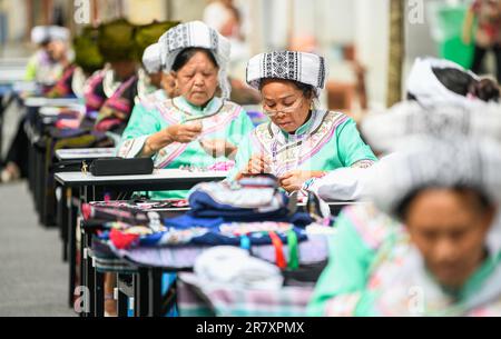 Les brodeurs travaillent dans un atelier à Qianxinan, province de Guizhou, Chine, 18 juin 2023. Banque D'Images