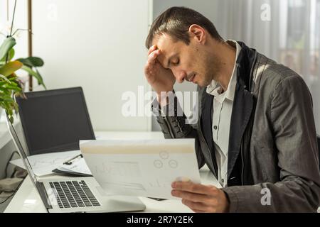 Contrarié a souligné inquiet caucasien homme investisseur boursier, courtier, expert financier, s'asseoir au bureau devant l'ordinateur avec des cartes, nerveux de la chute Banque D'Images