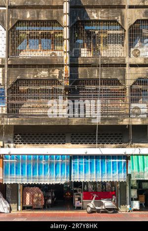 Immeuble d'appartements dans le quartier chinois de Bangkok, l'un des plus grands du monde. Toutes les fenêtres sont barrée. Différents magasins et magasins au rez-de-chaussée Banque D'Images