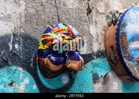 Un masque de comédie napolitaine Pulcinella accroché sur le mur des rues de Naples Banque D'Images