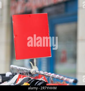 Affiche vierge rouge avec espace de texte devant un magasin Banque D'Images