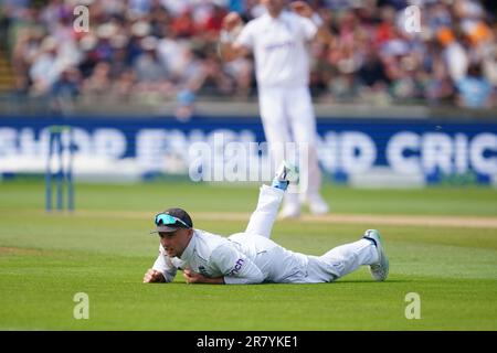 Joe Root, de l’Angleterre, se penche sur la question après avoir tenté d’arrêter une balle avivée par Alex Carey, de l’Australie (non représenté), au cours du troisième jour du premier match de test des cendres à Edgbaston, Birmingham. Date de la photo: Dimanche 18 juin 2023. Banque D'Images