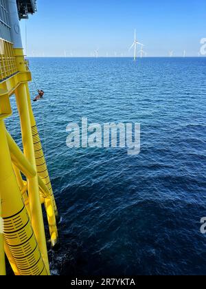 Techniciens d'accès à la corde IRATA, descendant sur une plate-forme offshore en mer du Nord. Banque D'Images