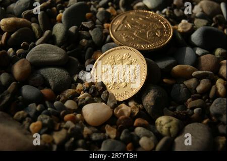 Vieilles pièces de monnaie d'or russes et françaises sur des pierres. 5 rouble et 20 francs. Banque D'Images