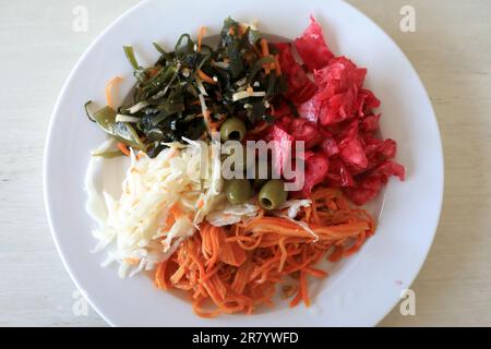 Salades de légumes mélangées sur une assiette blanche au restaurant Banque D'Images