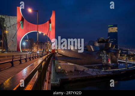 Bilbao, Espagne - 15 avril 2022 : vue sur la rive de la Nervión avec le musée Guggenheim, la tour Iberdrola et les arches rouges de Daniel Buren Banque D'Images