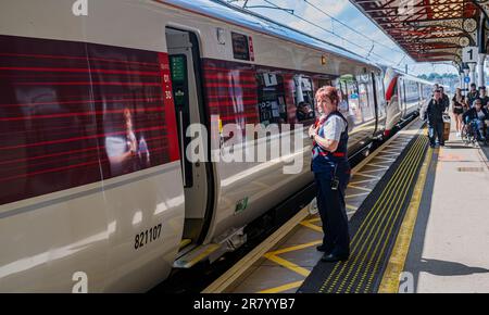 Gare de Grantham – Une femme chef d'orchestre ou garde qui expédie un train Azuma du nord-est (LNER) de Londres depuis la plate-forme Banque D'Images