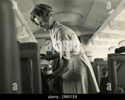 Agent de bord Alitalia servant des boissons pendant le vol, Italie 1950s Banque D'Images