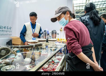 (230618) -- LHASSA, 18 juin 2023 (Xinhua) -- Un visiteur regarde l'artisanat tibétain à l'exposition touristique et culturelle de Xizang en 5th à Lhassa, capitale de la région autonome du Tibet du sud-ouest de la Chine, 18 juin 2023. L'expo est l'un des événements les plus importants du calendrier culturel du Tibet. (Xinhua/Sun Fei) Banque D'Images