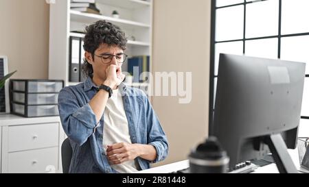 Jeune homme d'affaires hispanique utilisant la toux d'ordinateur au bureau Banque D'Images