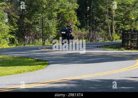 moto noire avec phares sur la conduite sinueuse route de montagne mouvement deux cavaliers Banque D'Images