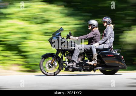 photo panoramique de la moto noire avec deux cavaliers montrant le mouvement pendant qu'ils se trouvent sur les routes des montagnes Banque D'Images