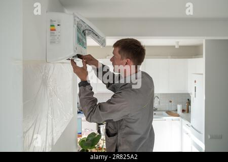 Homme technicien répare la climatisation de l'appartement Banque D'Images